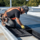 A professional installing flat roof air vents to ensure proper airflow and prevent moisture buildup.