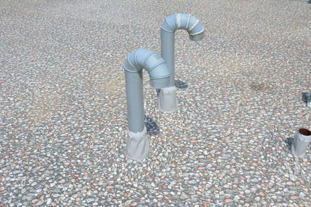 Close view of flashed vent-pipe penetrations on a granulated cap-sheet roof
