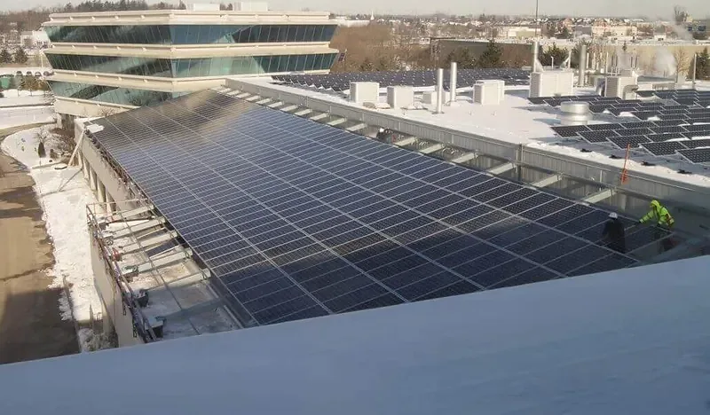 Low-angle view across a large rooftop photovoltaic array