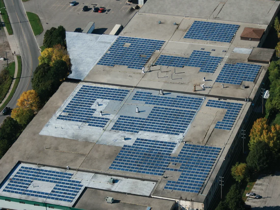 Aerial view of a large photovoltaic array across a commercial flat roof