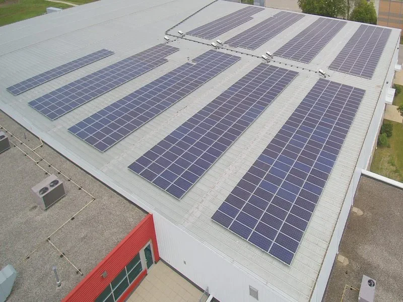 Aerial view of photovoltaic panels installed across a white commercial roof