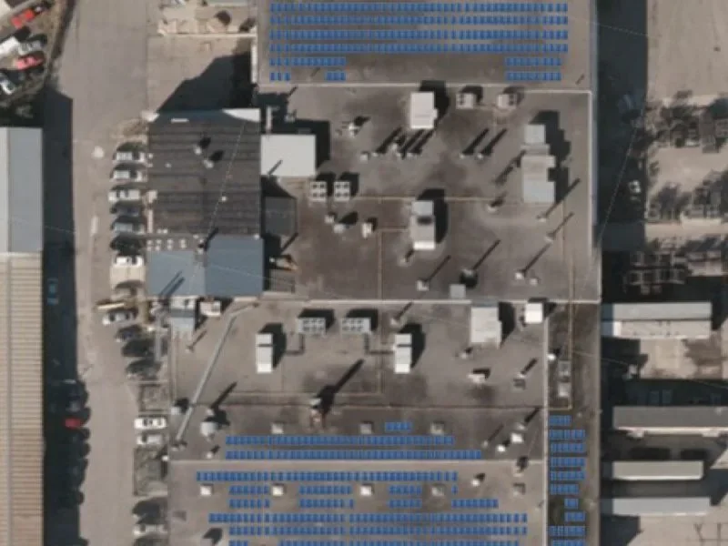 Aerial view of photovoltaic arrays across a large commercial and industrial roof